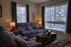 a living room with a blue couch and two windows at Dunsmuir Getaway in Dunsmuir +32 photos