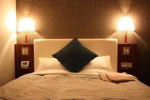 a bedroom with a bed with two lamps on it at Kanazawa Manten Hotel Ekimae in Kanazawa
