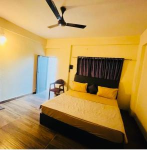 a bedroom with a bed and a ceiling fan at Raj Hotel in Talala