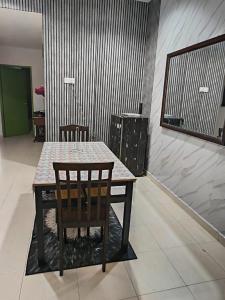 a table with two chairs and a table and a table and a table at Aisyhome in Jitra