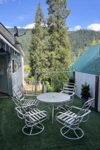 a patio with a table and chairs on the grass at Dunsmuir Getaway in Dunsmuir