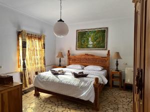 a bedroom with a bed and a painting on the wall at Mangga Lodge in Bira
