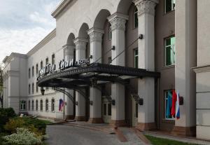 a building with a balcony on the side of it at Grand Tien Shan Hotel in Almaty