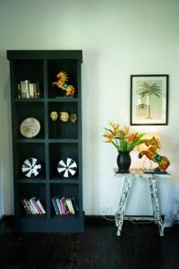 una estantería de libros negros con una mesa con una planta. en Ginganga Lodge, en Galle