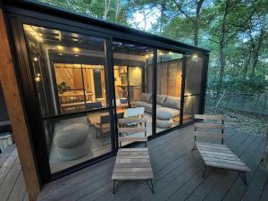 a large glass house with benches on a deck at Forest 99 in Nasushiobara