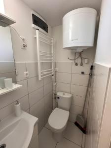 a white bathroom with a toilet and a sink at ZitaLaka in Igal