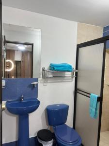 a bathroom with a blue toilet and a sink at JARDIN DE TEQUENDAMA HOTEl in Cali +52 photos
