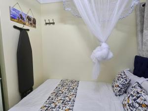 a bedroom with a bed and a window with a curtain at Favoured Guest House in Nairobi