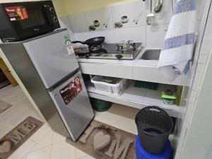 a small kitchen with a refrigerator and a sink at Favoured Guest House in Nairobi +11 photos