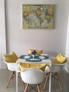a table and chairs with a map on the wall at DKaYa Hostel in Khao Lak