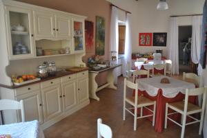 a kitchen with a table and a dining room at Palazzo Bonfranceschi in Belforte del Chienti