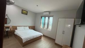 a small bedroom with a bed and a window at Hưng Phát Hotel Nghệ An in Vinh