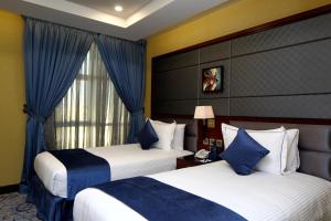 a hotel room with two beds and a window at Intour Al Khafji Hotel in Khafji