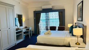 a hotel room with a bed and a desk and a window at Rainbow Paradise Seaview by Achlys Collection in Tanjung Bungah +89 photos