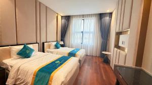 a hotel room with two beds and a window at Diamond Hotel Bỉm Sơn Thanh Hóa in Bỉm Sơn