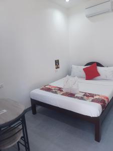 a bed in a room with a table and a bed sidx sidx sidx at Sebastian Guest House in Moalboal