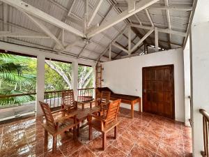 a dining room with a wooden table and chairs at Mangga Lodge in Bira