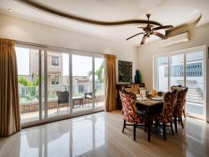 a dining room with a table and chairs and a large window at DanCenter Vana Villa I 5BHK I Pvt Pool I Baga I GOA in Goa