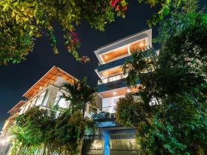 a tall white building with trees in front of it at DanCenter Vana Villa I 5BHK I Pvt Pool I Baga I GOA in Goa