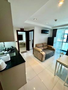 a kitchen and living room with a couch in a room at Apartment Serenity Wongamat in North Pattaya