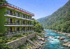 a building on the side of a river at Hotel MountMemory , Barkot-Yamunotri in Barkot
