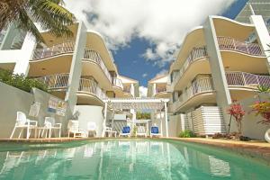 a hotel with a swimming pool in front of a building at Salad Days -Beachfront & Pet Friendly in Marcoola