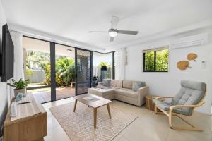 a living room with a couch and a table at Salad Days -Beachfront & Pet Friendly in Marcoola