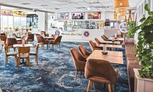 a restaurant with tables and chairs on a blue carpet at Salad Days -Beachfront & Pet Friendly in Marcoola