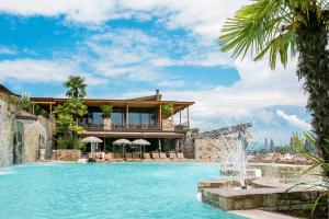 a large swimming pool in a tropical setting at Le Ali Del Frassino in Peschiera del Garda