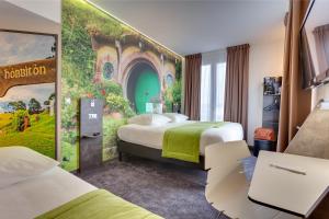 een hotelkamer met 2 bedden en een muurschildering bij Hôtel Kyriad Rennes in Rennes