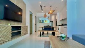 a living room with a table and a kitchen at Grand Kamala Falls in Kamala Beach