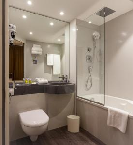 a bathroom with a shower and a toilet and a sink at Hôtel Kyriad Rennes in Rennes