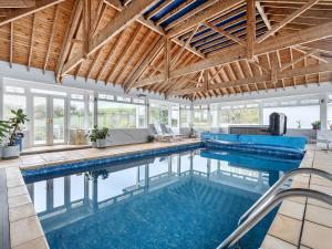 an indoor swimming pool with a couch and a table at Chapel Green Studio 2 in St Austell