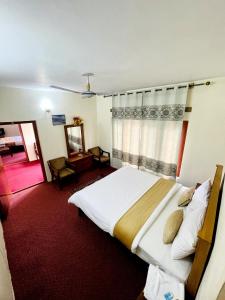 a bedroom with a large bed and a window at Indus Motel in Skardu