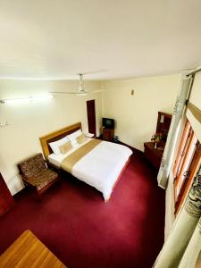 a bedroom with a bed and a red carpet at Indus Motel in Skardu +16 photos