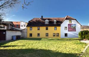 a yellow and white house with a yard at hausamsolschacht in Bad Kösen