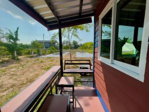 a porch of a house with benches and a window at Lamai Home 2 in Ko Yao Noi