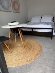a room with a bed and a table and a bed gmaxwell gmaxwell gmaxwell at Cozy Pakura Pad in Te Awamutu