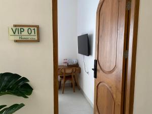 a room with a door and a table with a television at Numar Villas Yogyakarta in Seturan