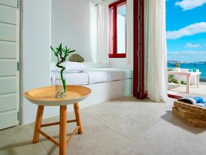 a room with a table with a vase on it at Unique Milos Suites in Pollonia