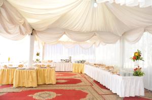 a large white tent with tables in a room at Hotel Transatlantique in Meknès