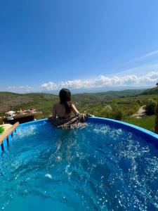 a woman sitting in a swimming pool with a view at Panorama Lupilor in Coleşti