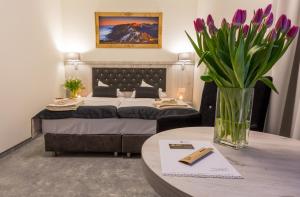 a bedroom with a bed and a table with a vase of flowers at Grand Tatry in Białka Tatrzanska