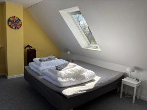 a bed in a room with a window at Tante Jannis Sommerpension in Bogense