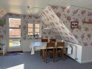 a dining room with a table and chairs and flowers at Tante Jannis Sommerpension in Bogense