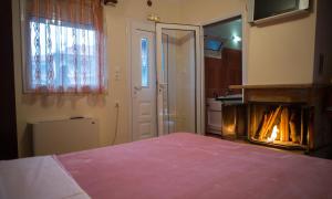 a bedroom with a bed and a fire place at Voras Apartments in Kato Loutraki +3 photos