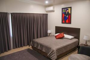 a bedroom with a bed and a window with curtains at Boonah Valley Motel in Boonah