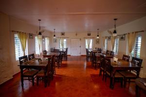 a dining room with wooden tables and chairs at Stanmore Garden Bungalow in Vālpārai
