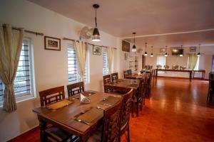 a dining room with wooden tables and chairs at Stanmore Garden Bungalow in Vālpārai