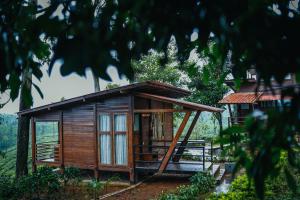 a small wooden house in a forest at Stanmore Garden Bungalow in Vālpārai